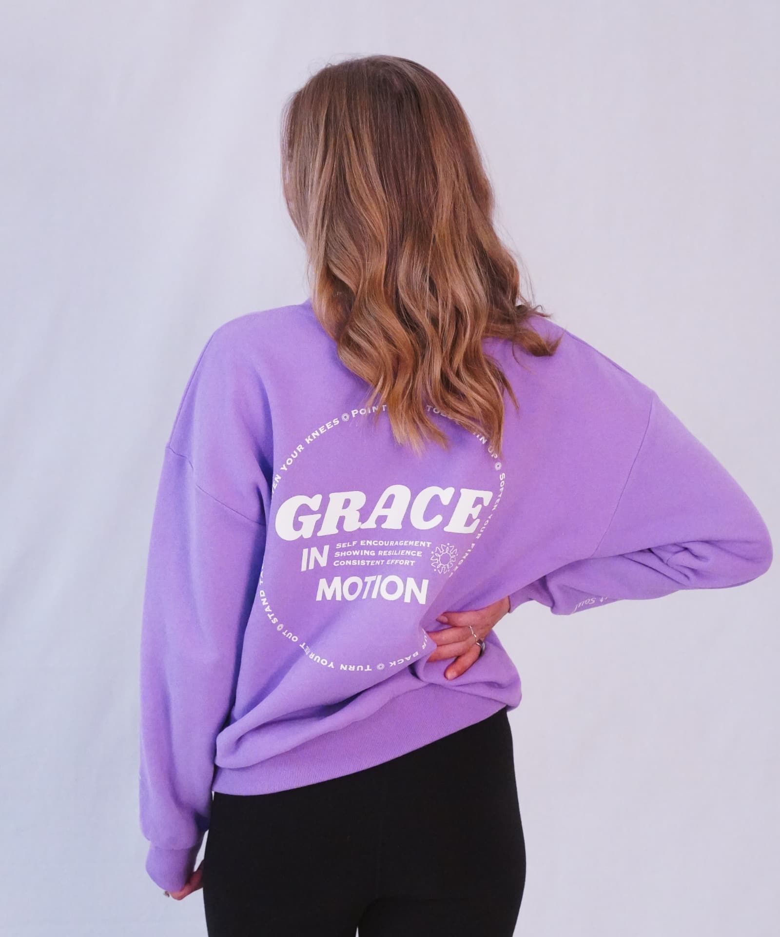 Model wearing the orchid Grace in Motion crewneck from the back
